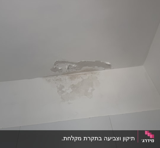 קילופי צבע ונזקי רטיבות בתקרה ובקיר חדר אמבטיה לפני צביעה